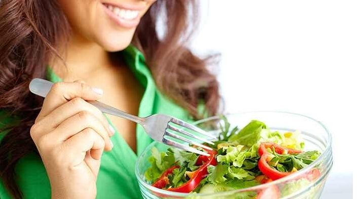 The girl who is eating a vegetable salad on a protein diet